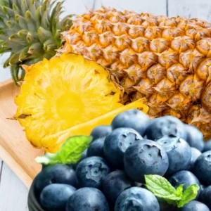 A close up of pineapple and blueberries on a table