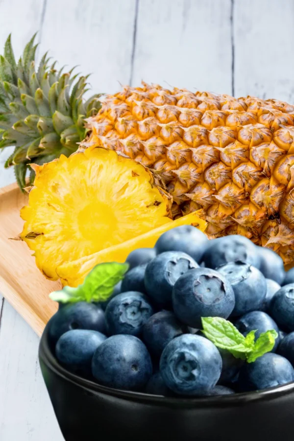 A close up of pineapple and blueberries on a table