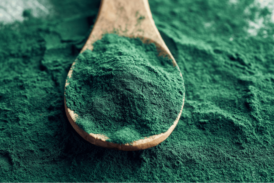 A wooden spoon with green powder on it.